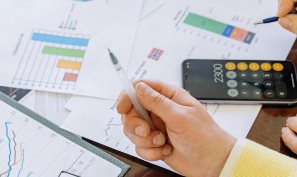 A close-up of businesspeople analyzing financial data and charts during a meeting.