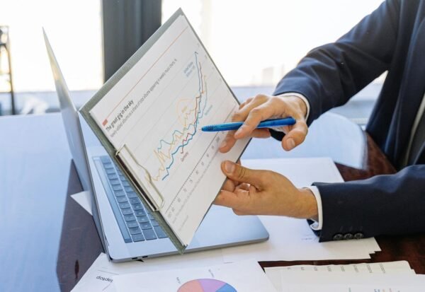 Business professionals discussing financial graphs and charts in an office setting.